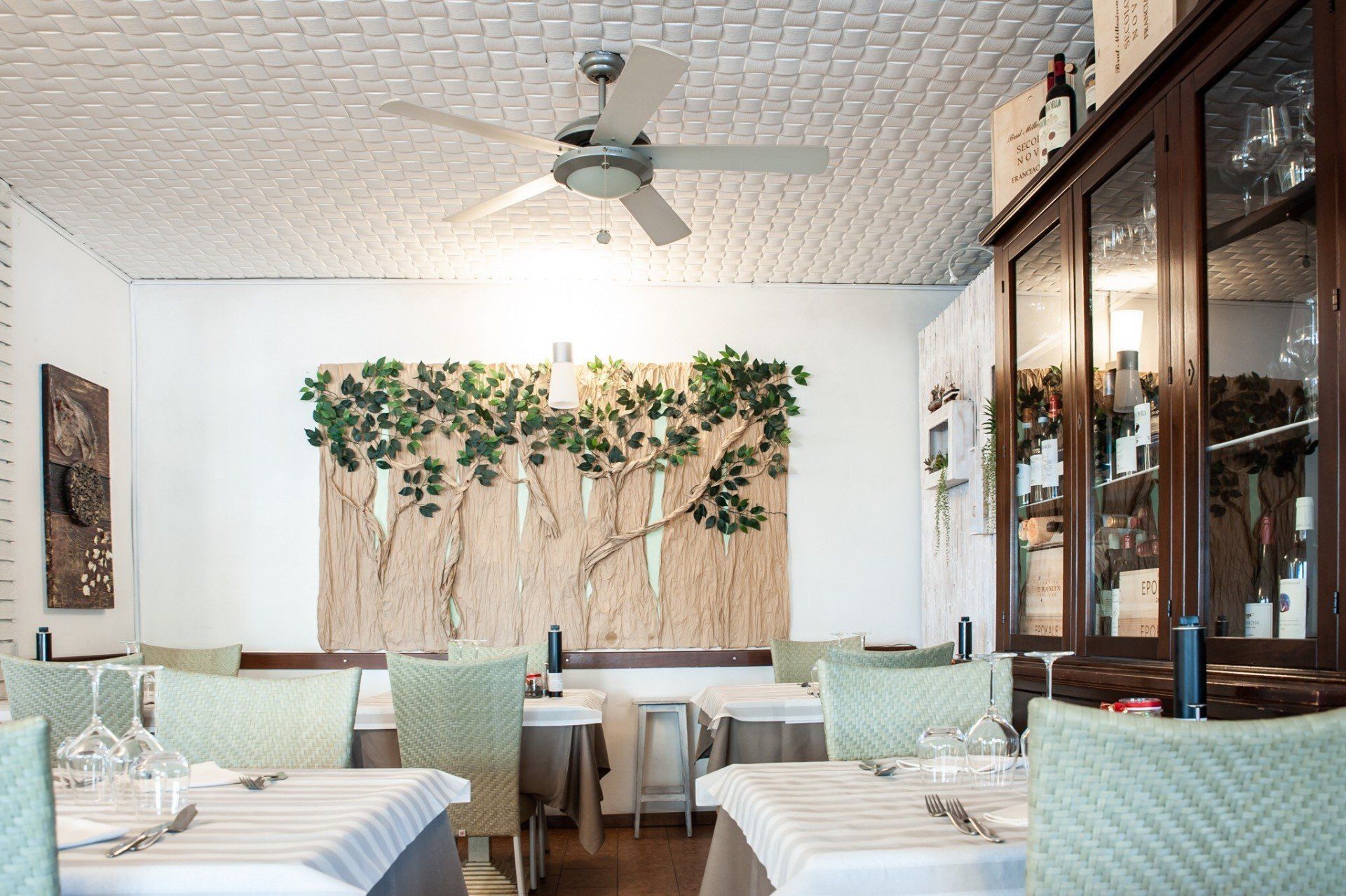 Un ristorante con tavoli e sedie e un ventilatore a soffitto