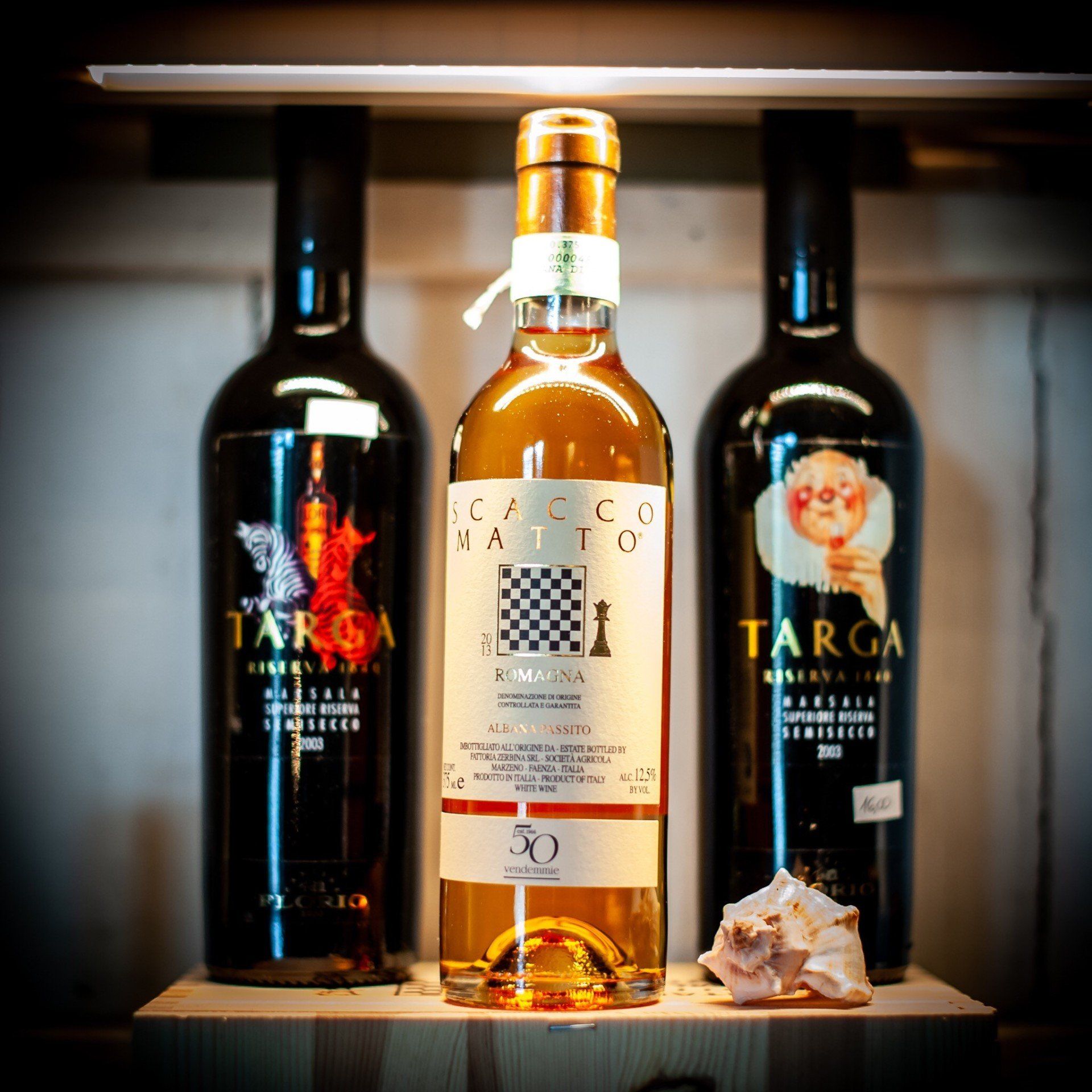 Tre bottiglie di vino targa sono su uno scaffale