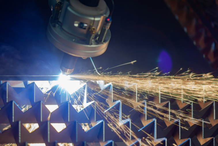 Laser cutting metal sheets with bright sparks in an industrial workshop