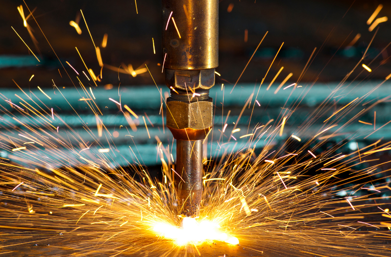 Metal cutting torch spraying bright orange sparks in a workshop