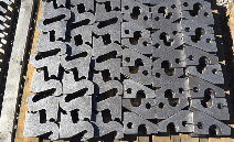 Stacked black and gray interlocking plastic panels on a concrete surface, viewed from above
