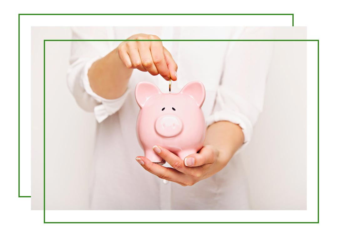 a person dropping money into a piggy bank