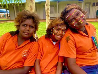 Students with face painting smiling at camera