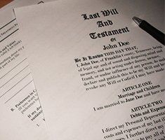 A pen is sitting on top of a last will and testament.