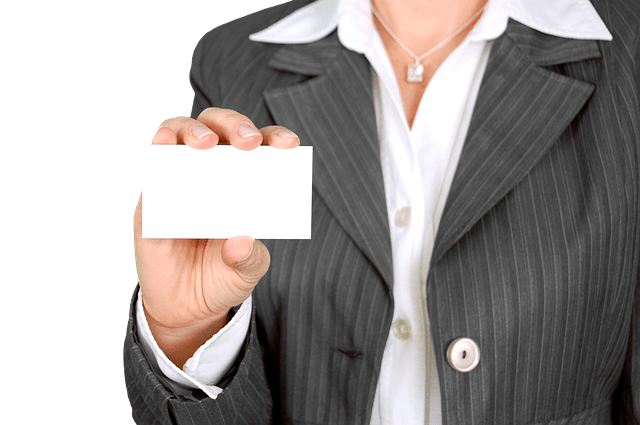 A woman in a suit is holding a white business card