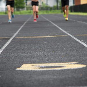 A group of people are running on a track.