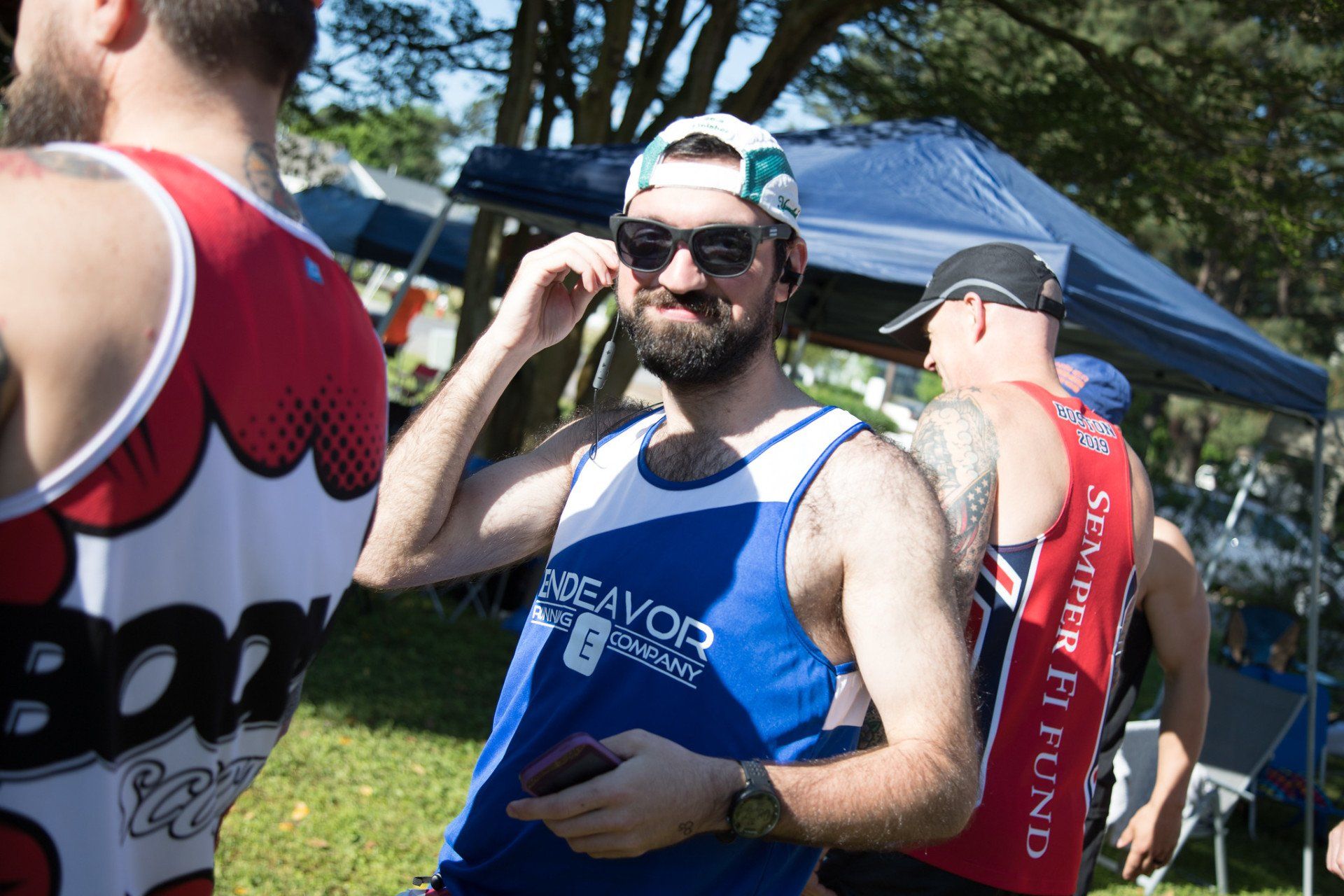 A man with a beard is wearing sunglasses and a baseball cap.