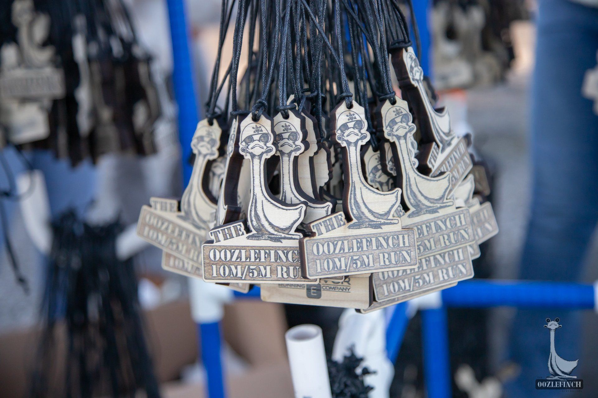 A bunch of medals are hanging from a fence.