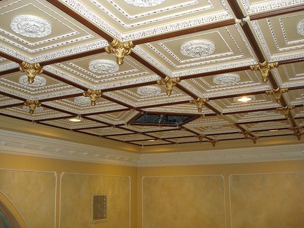Ornate coffered ceiling with gold and white detailing and decorative accents.