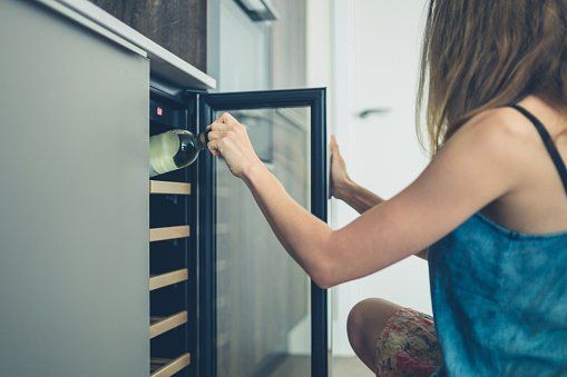 Freezer — Woman getting bottle of wine from cooler in Baton Rouge, LA