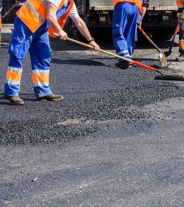 construction workers working paving a road