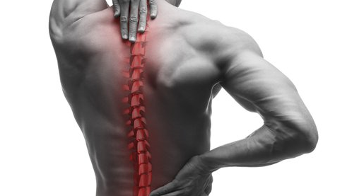 A man is holding his back in pain because of a backache.
