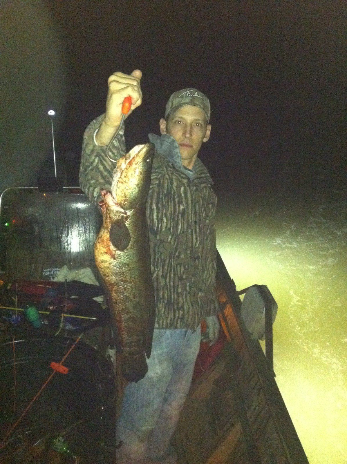 Man in the Boat Holding a Fish in a Hook — Lancaster County, PA — Night Ventures Bowfishing Charters