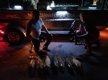 Bowfishing Adventures — Two Bowfishermen with their Catch in Low Light in Lancaster County, PA Bowfishing Adventures — Two Bowfishermen with their Catch in Low Light in Lancaster County, PA