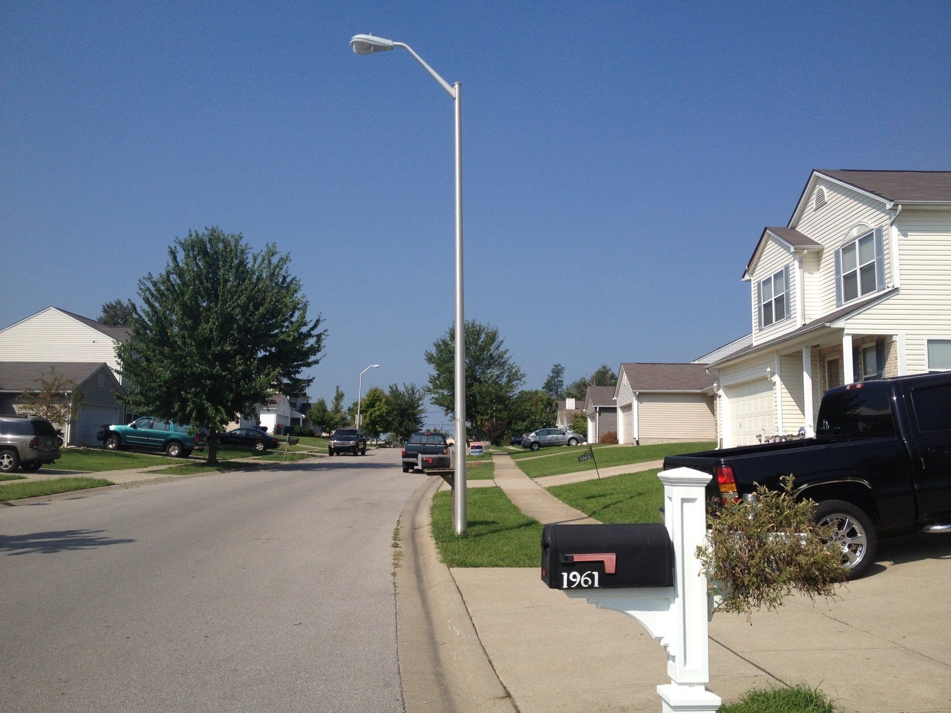 A black truck is parked in front of a mailbox that says 7361