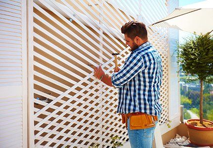 Deck Installation — Man fixing the Wood Fence in Portland, OR Deck Installation — Man fixing the Wood Fence in Portland, OR