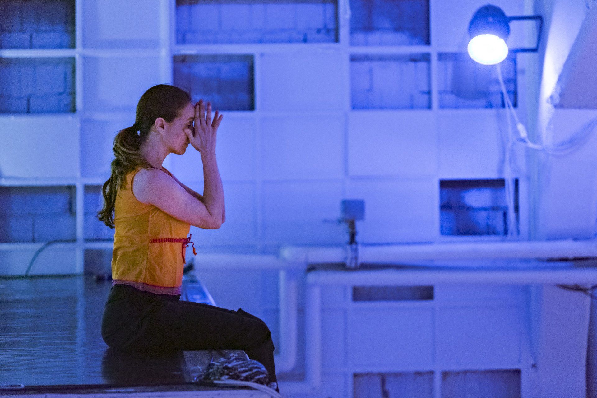 femme assise dans une pièce éclairée en bleu