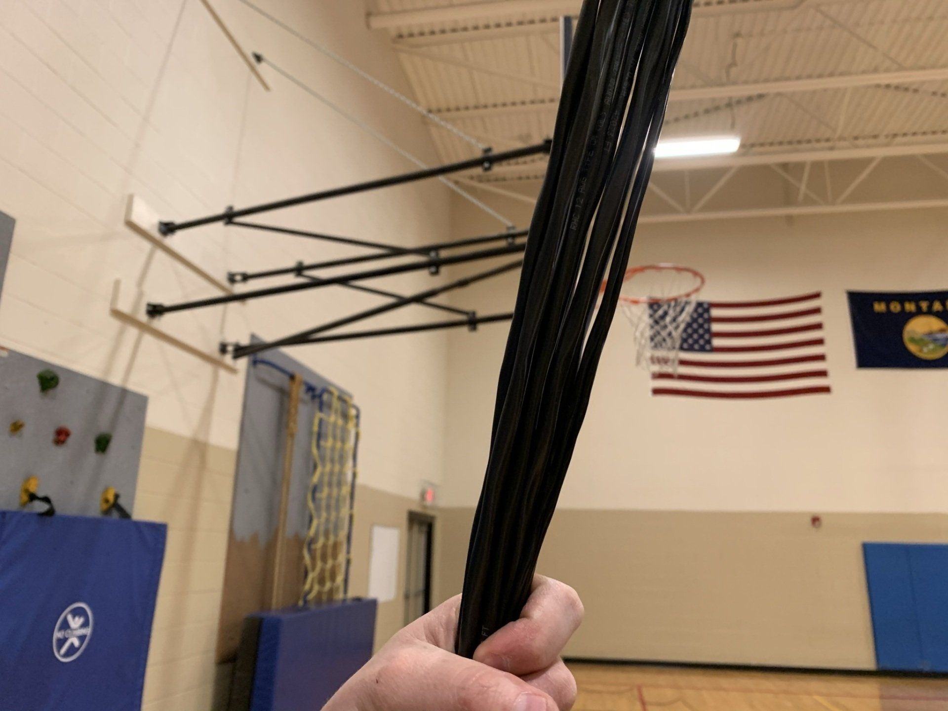 A person is holding a basketball hoop in a gym