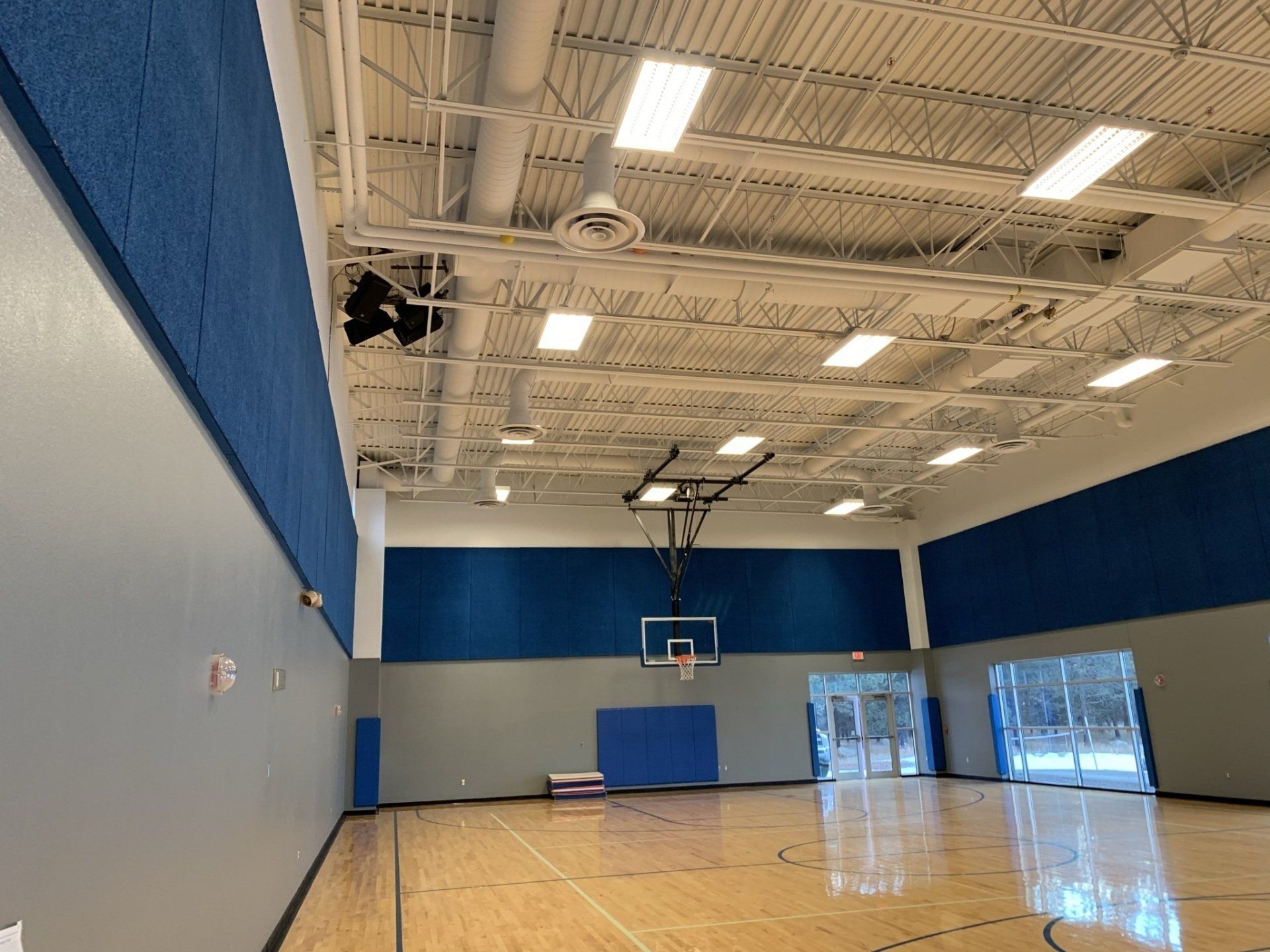 There is a basketball court in the middle of the gym.