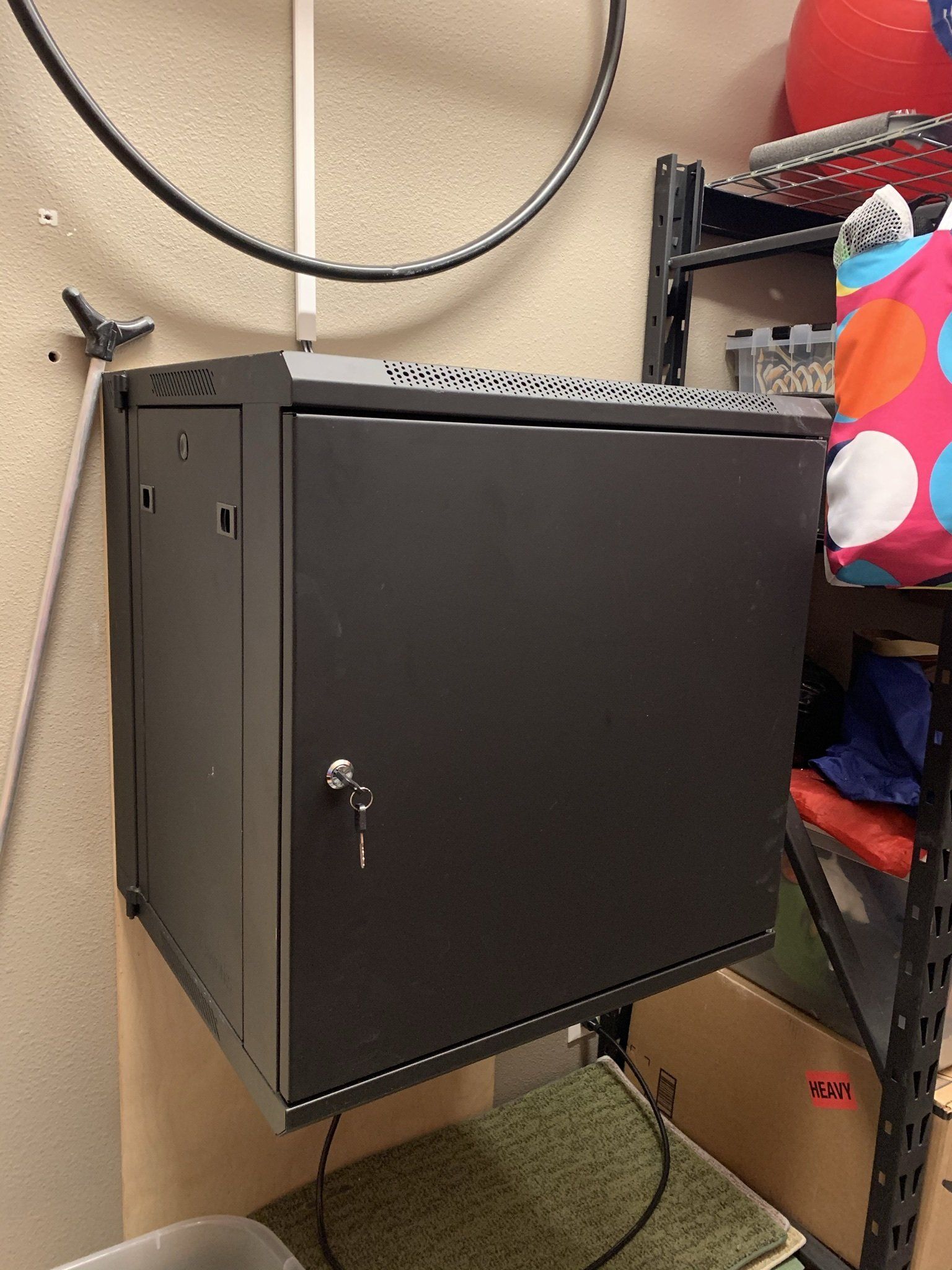 A black cabinet is hanging on a wall in a room.