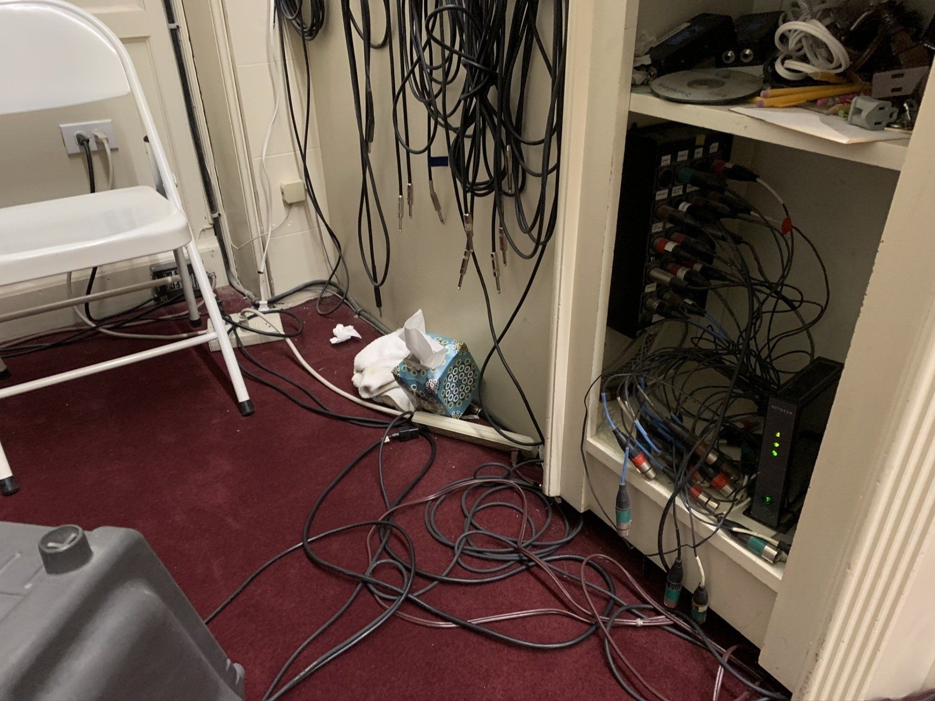 A room with a lot of wires and a chair