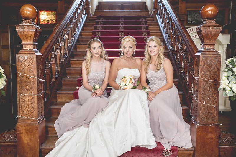 bride and bridesmaids wedding portraits on staircase with hair and makeup by Jax-Glam Beauty Bristol