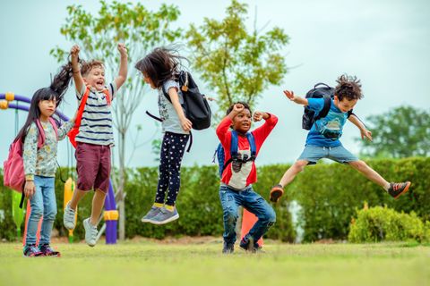 kids preschool kindergarten enjoy and happy jumping on the field of playground after school class is over to retuning home