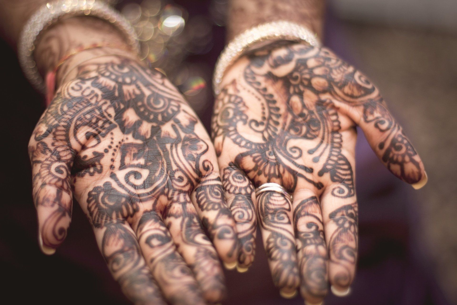 A close up of a person 's hands with henna on them.