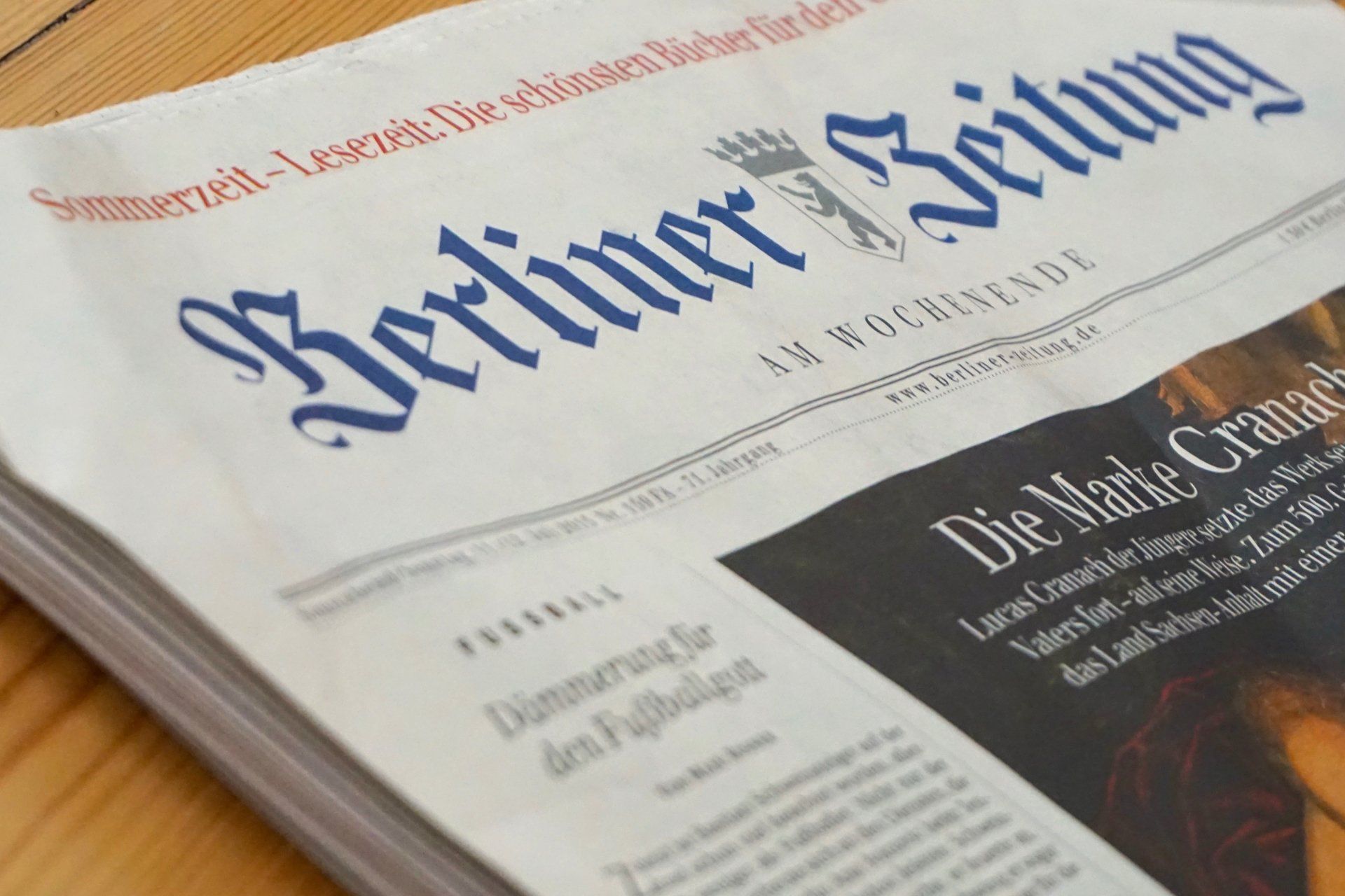 A berliner zeitung newspaper on a wooden table