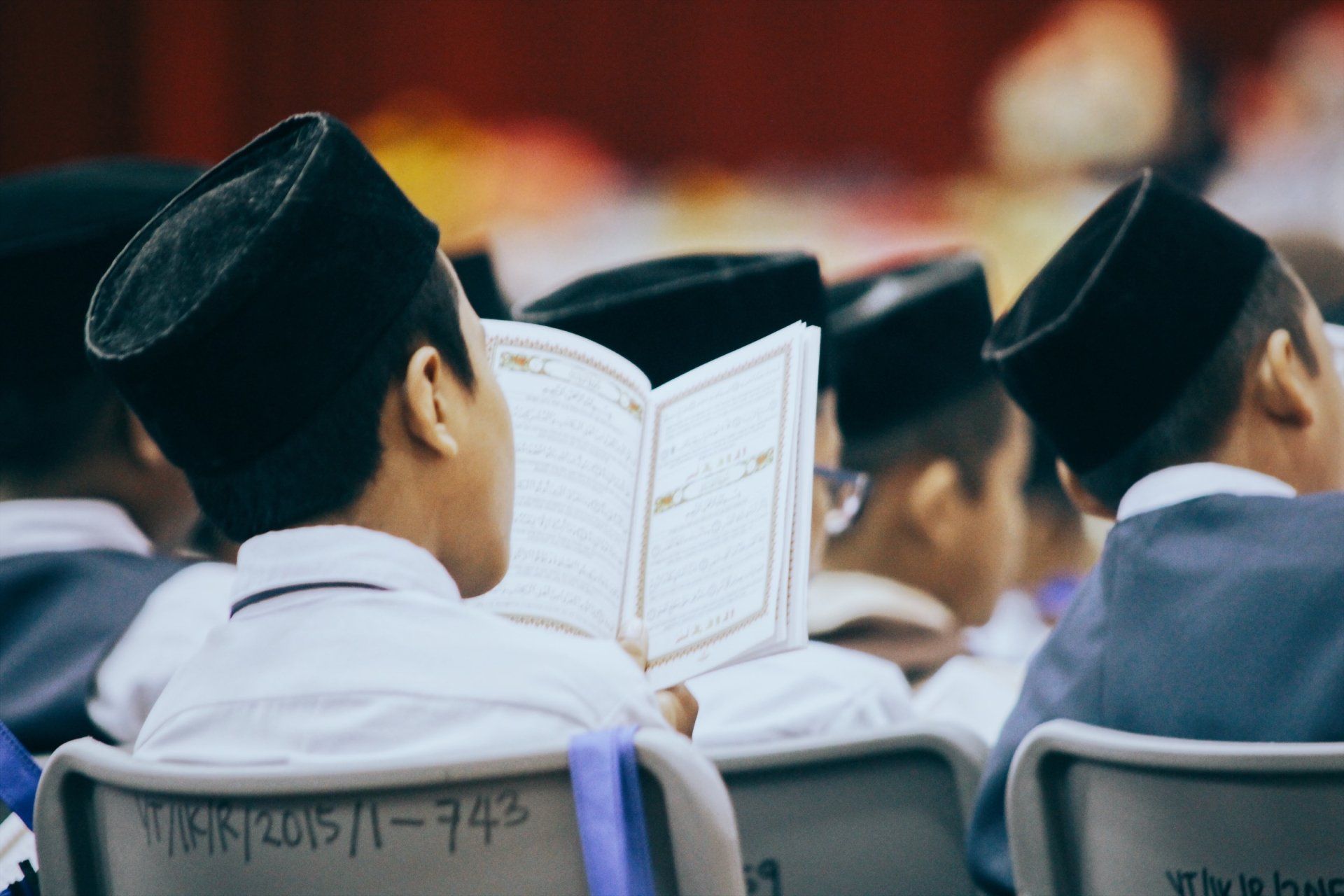 A group of people are sitting in chairs reading books.