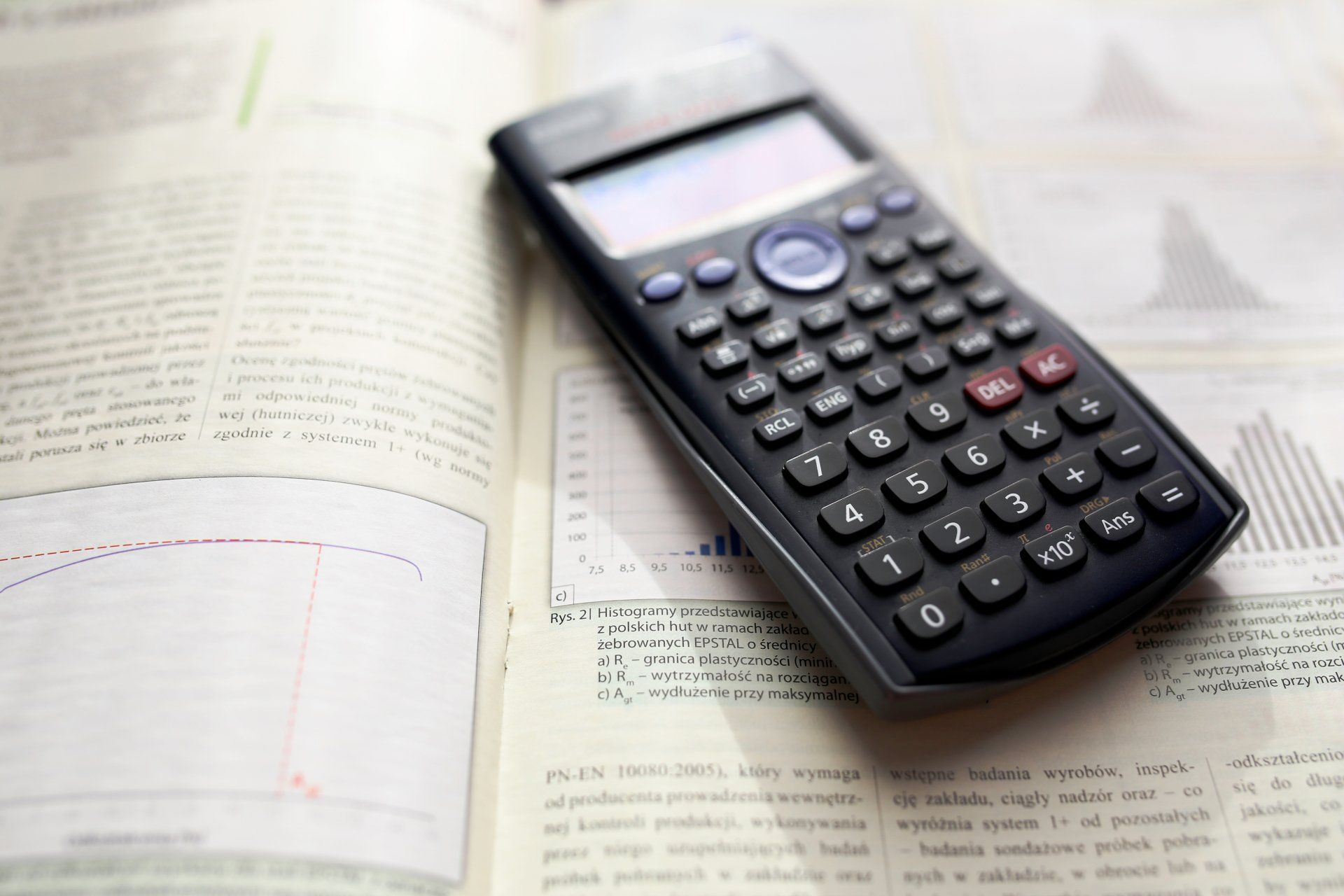 Photo by Kaboompics .com A calculator is sitting on top of an open book