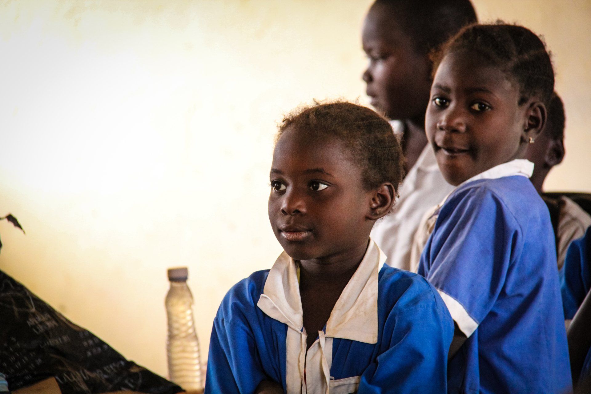 A group of young girls are sitting in a classroom.