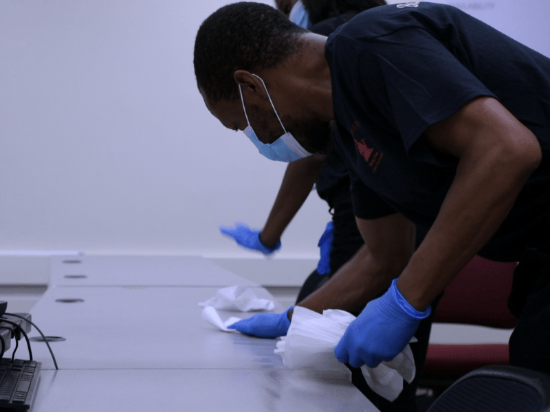 Day porters cleaning conference room tables