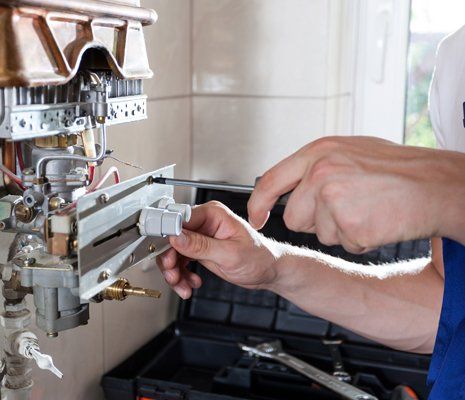 Heater Installation — Man Installing Heater in Lee, MA Heater Installation — Man Installing Heater in Lee, MA