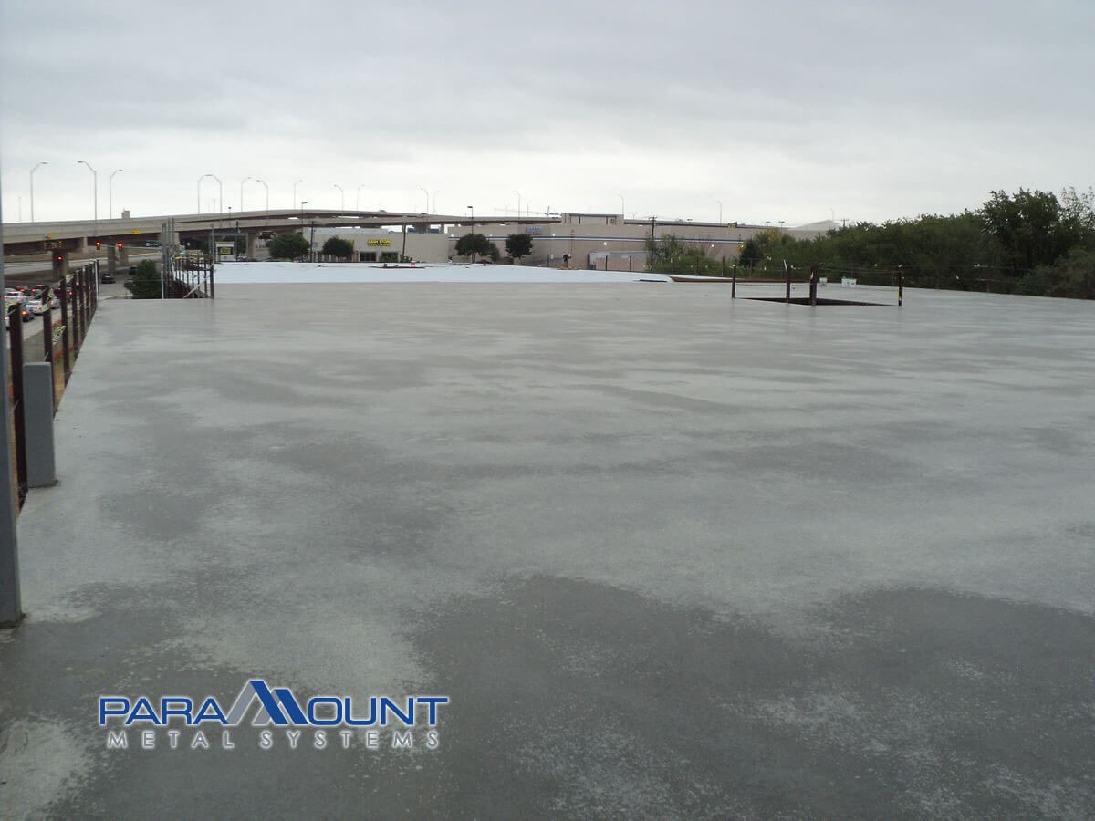 A large, smooth, gray concrete surface with a cloudy sky backdrop.