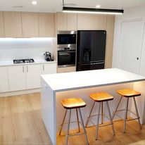 Indoor White Kitchen With Stools — DMB Kitchens in Port Macquarie, NSW