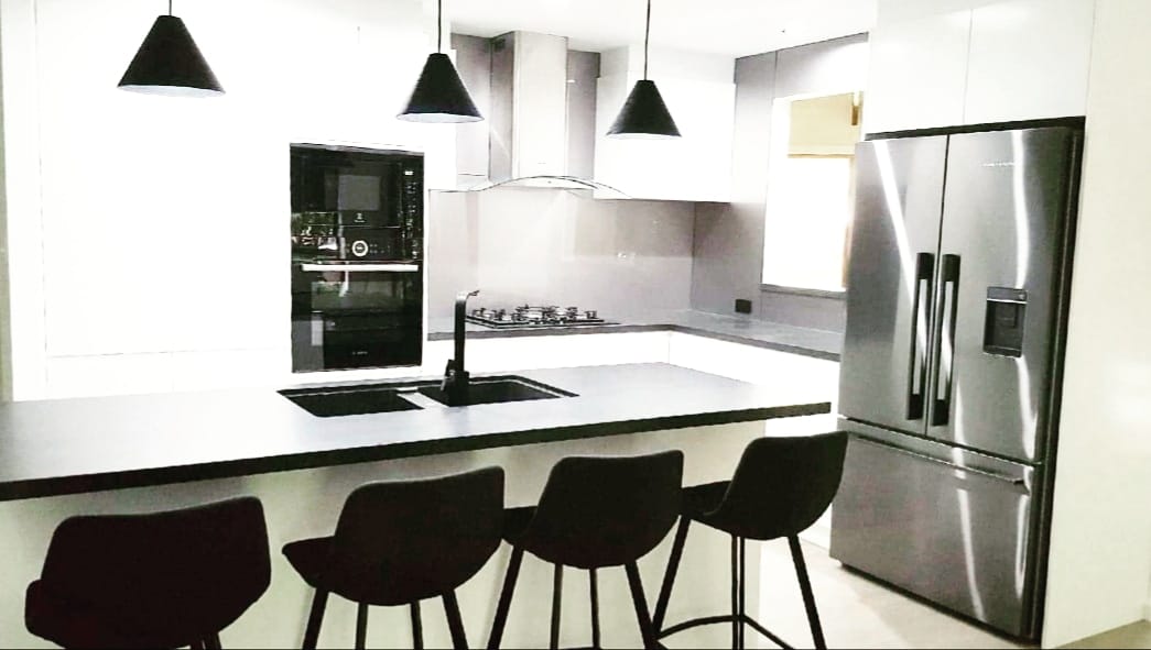 Kitchen Island With Black Chairs — DMB Kitchens in Port Macquarie, NSW
