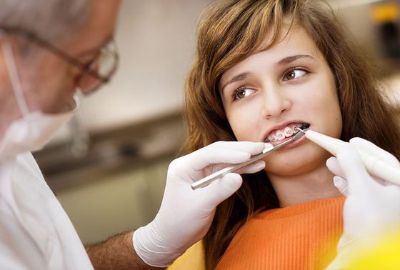 Teenage girl with the braces on her teeth is having a treatment at dentist Teenage girl with the braces on her teeth is having a treatment at dentist
