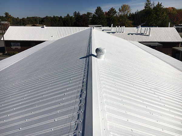 A white roof with a chimney on top of it