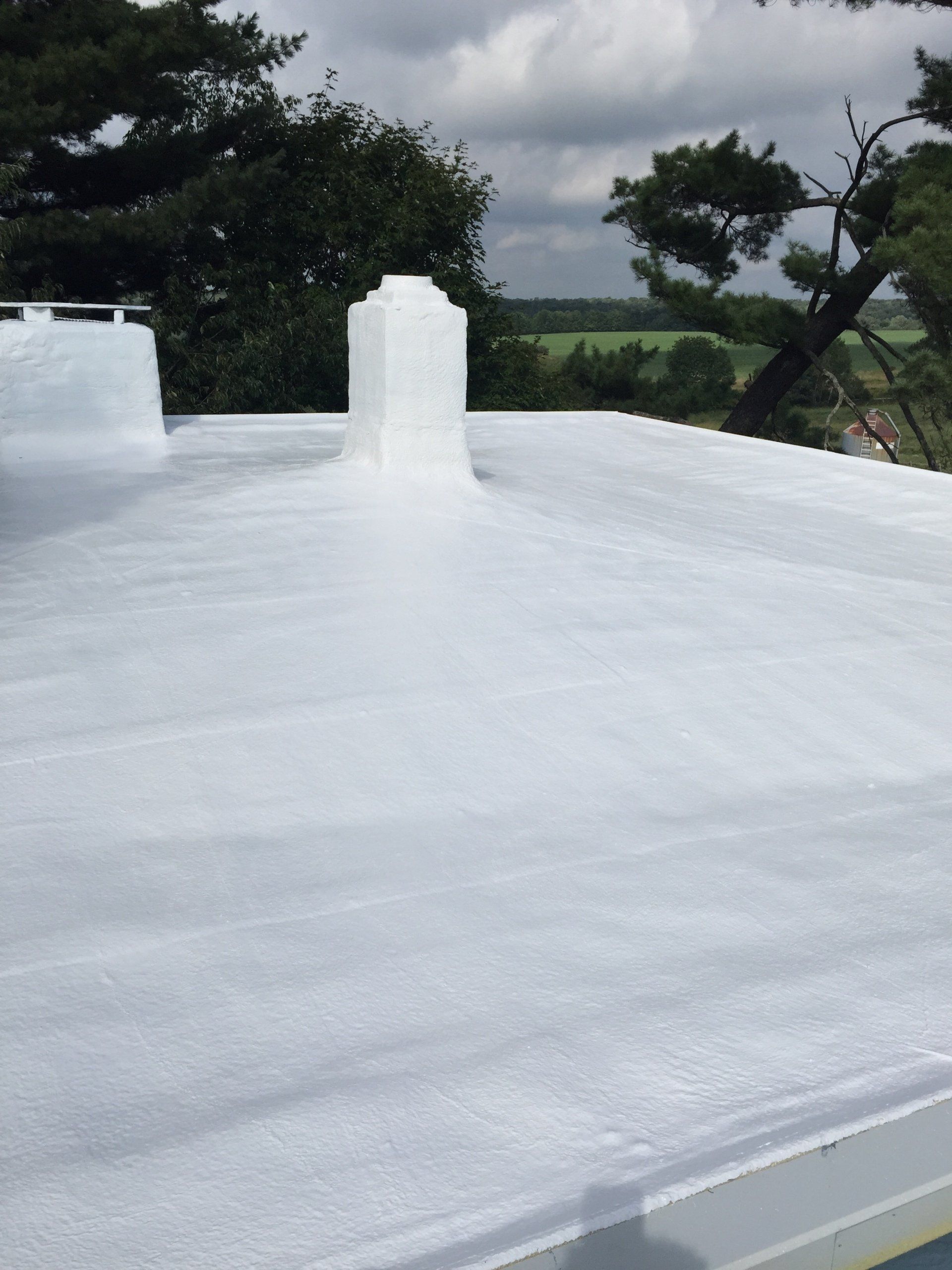 A white roof with a chimney on top of it