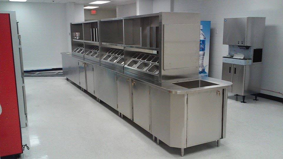 A kitchen with stainless steel appliances and a coca cola vending machine