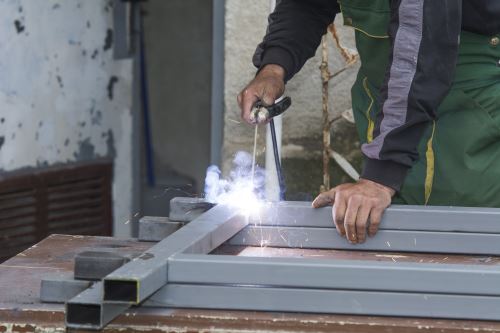 un carpentiere salda dei tubi metallici
