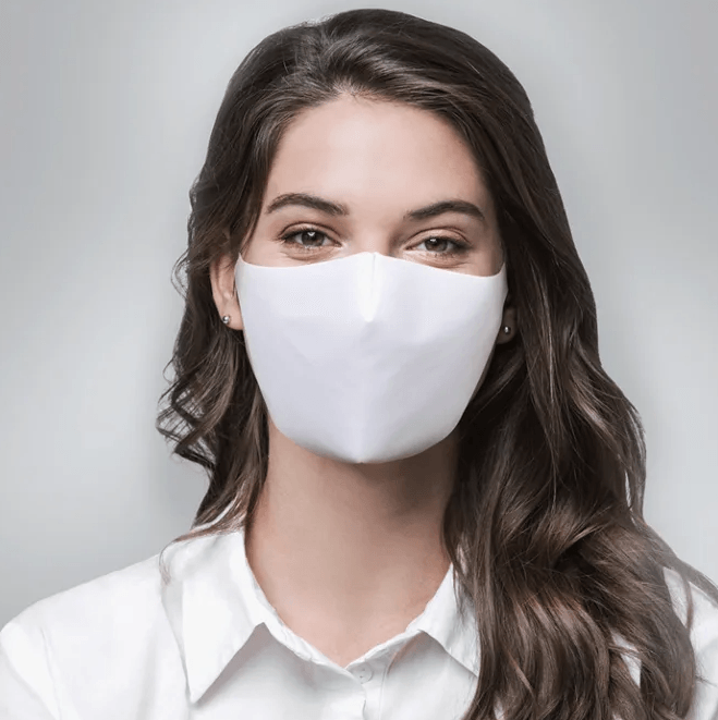 Een vrouw met een wit gezichtsmasker en een wit overhemd.