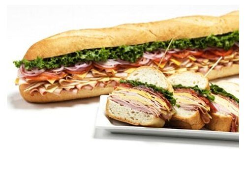 Two sandwiches are sitting on a white plate on a table.