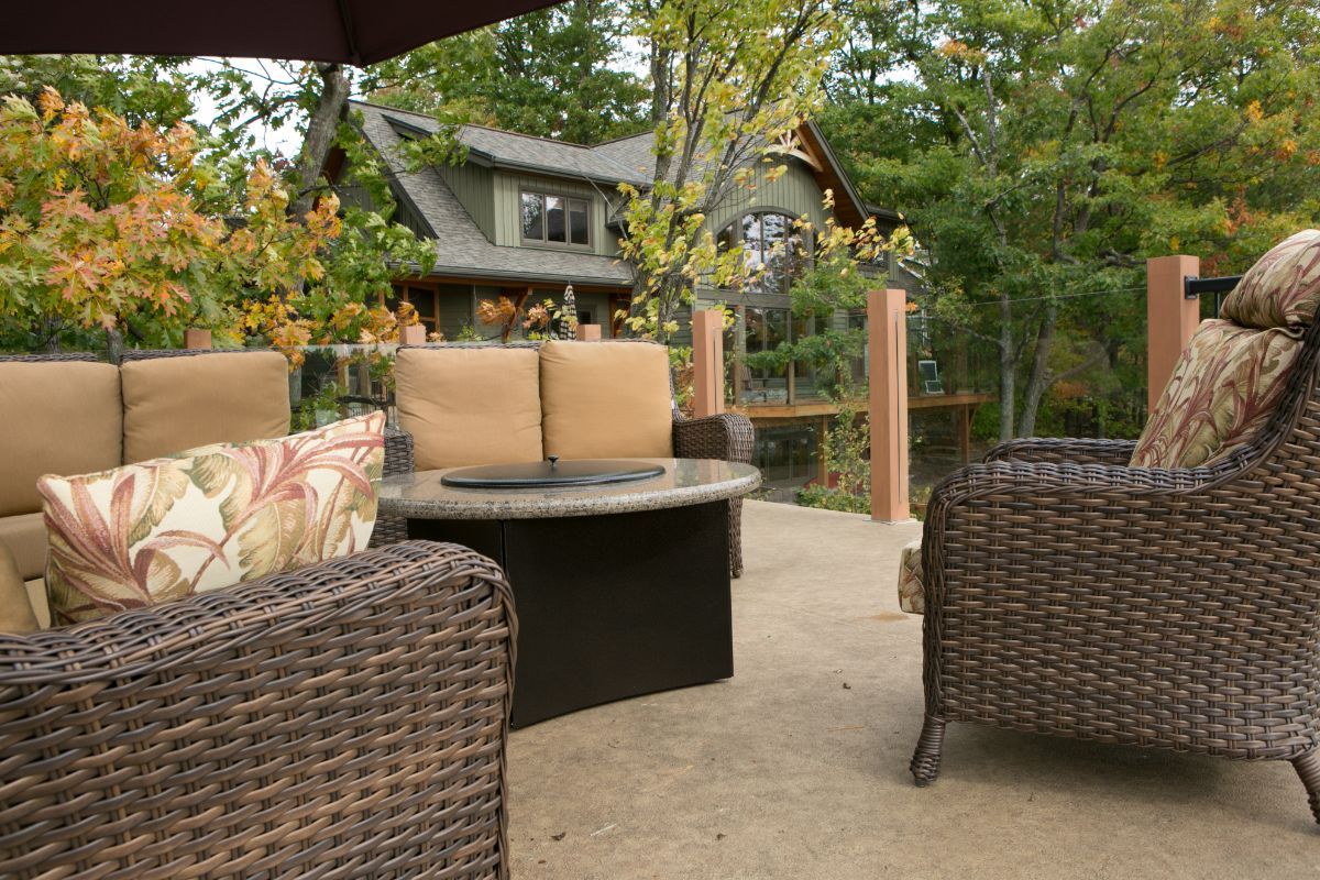Custom Muskoka Cottage featuring a patio with wicker furniture and a fire pit
