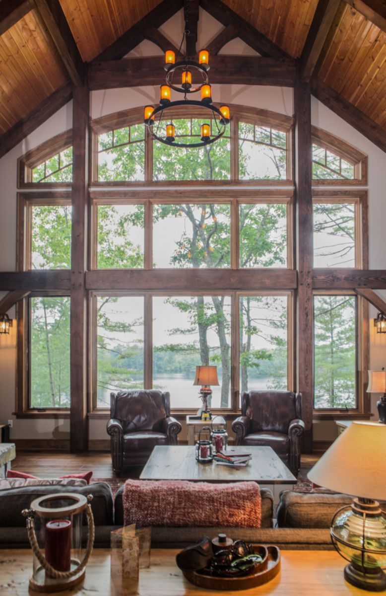 Custom Muskoka Cottage featuring a living room with a lot of windows and a chandelier