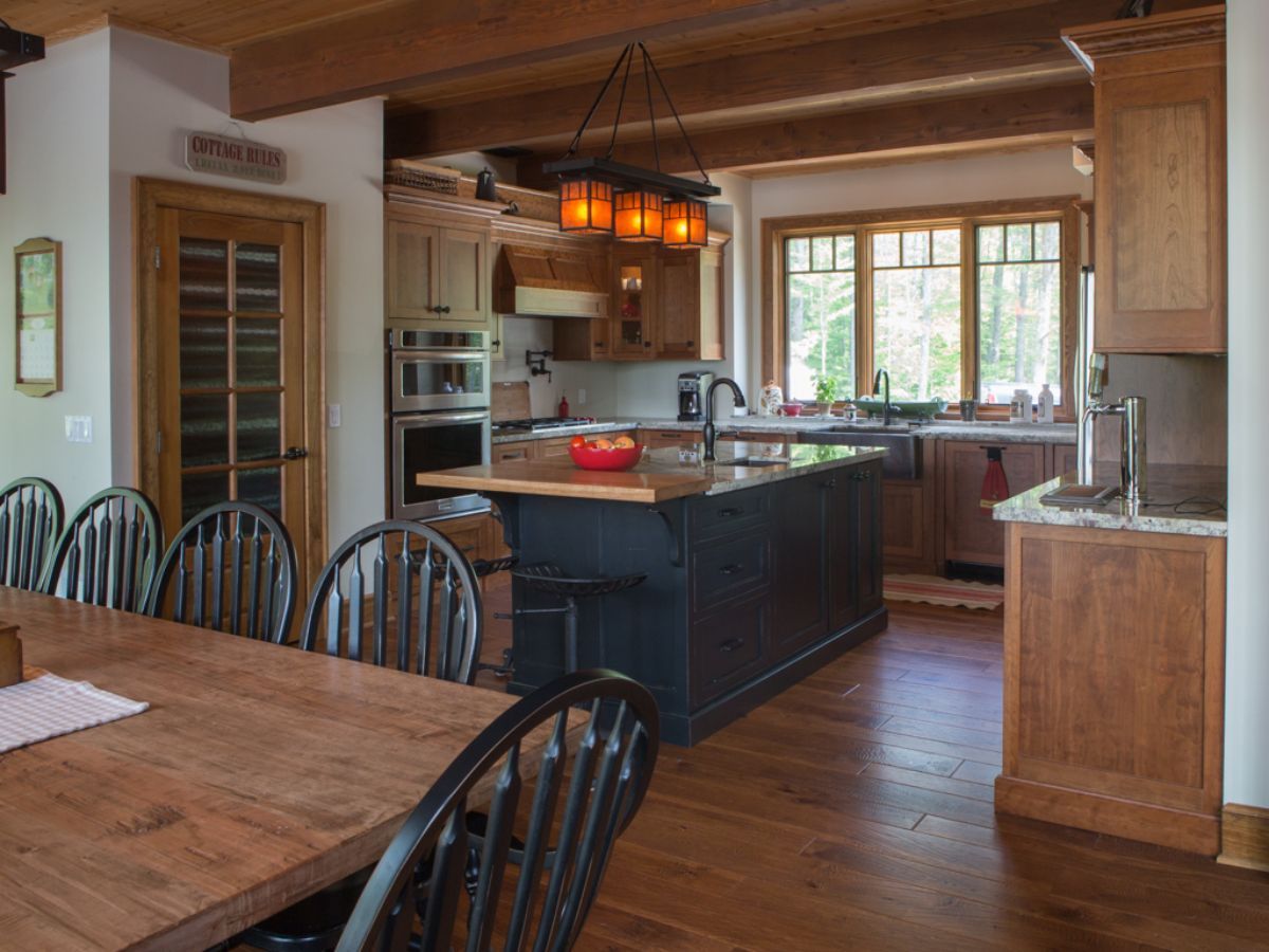 Custom Muskoka Cottage featuring a kitchen with a large island and a wooden table and chairs