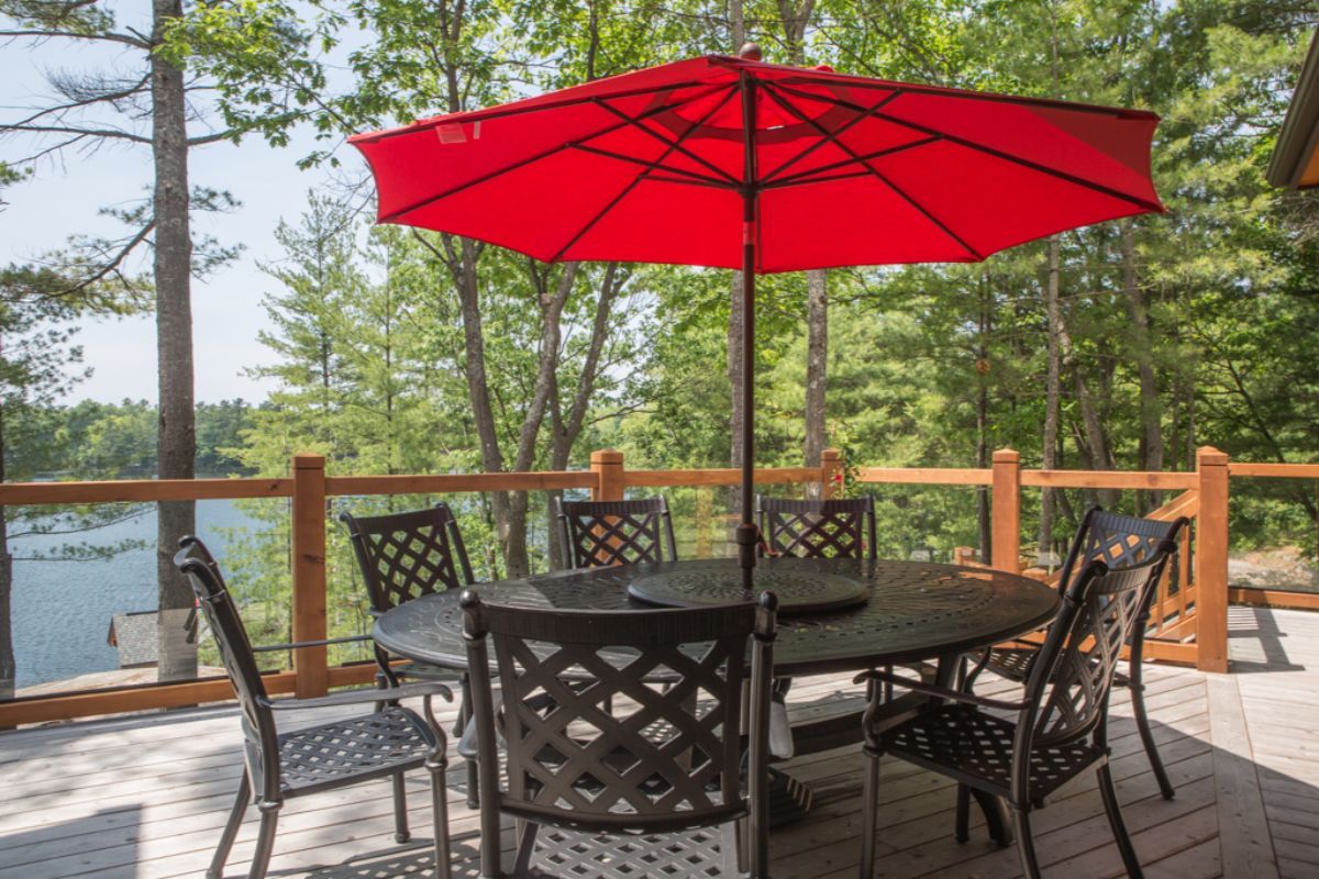 Custom Muskoka Cottage featuring a table and chairs on a deck with a red umbrella