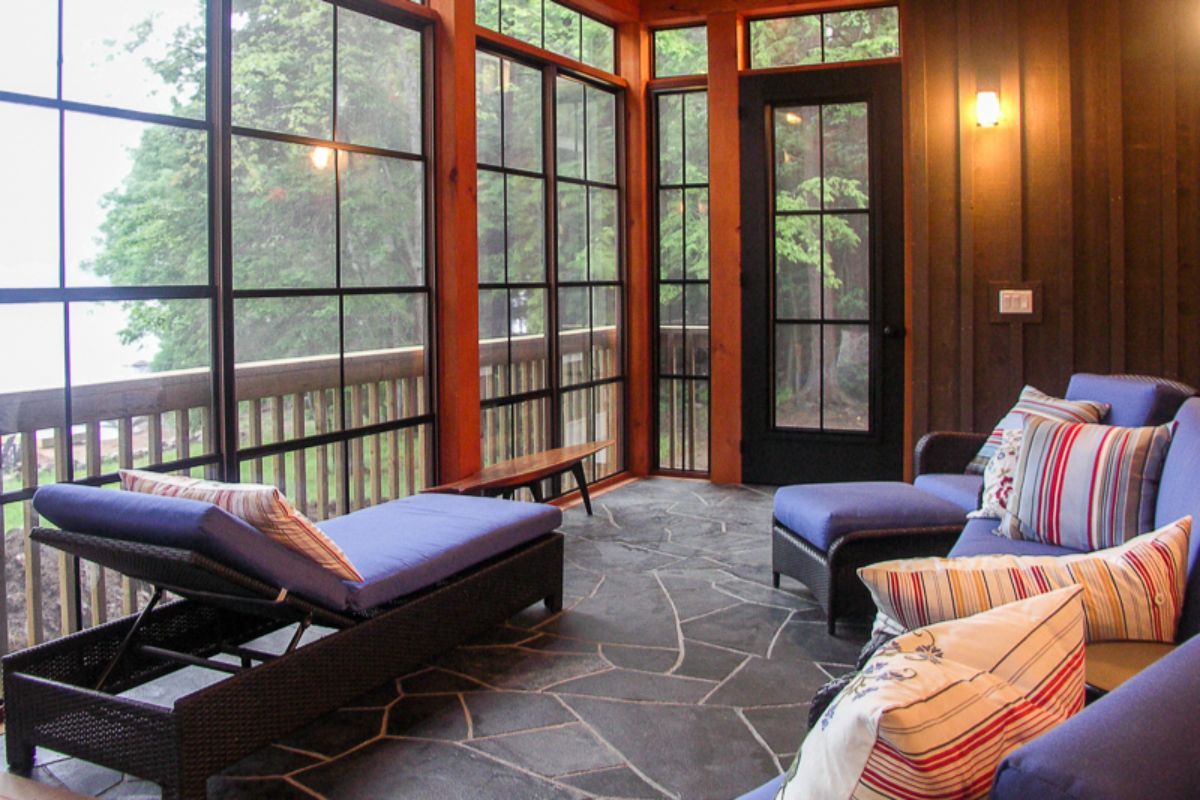 Custom Muskoka Cottage featuring a screened in porch with a couch and chairs