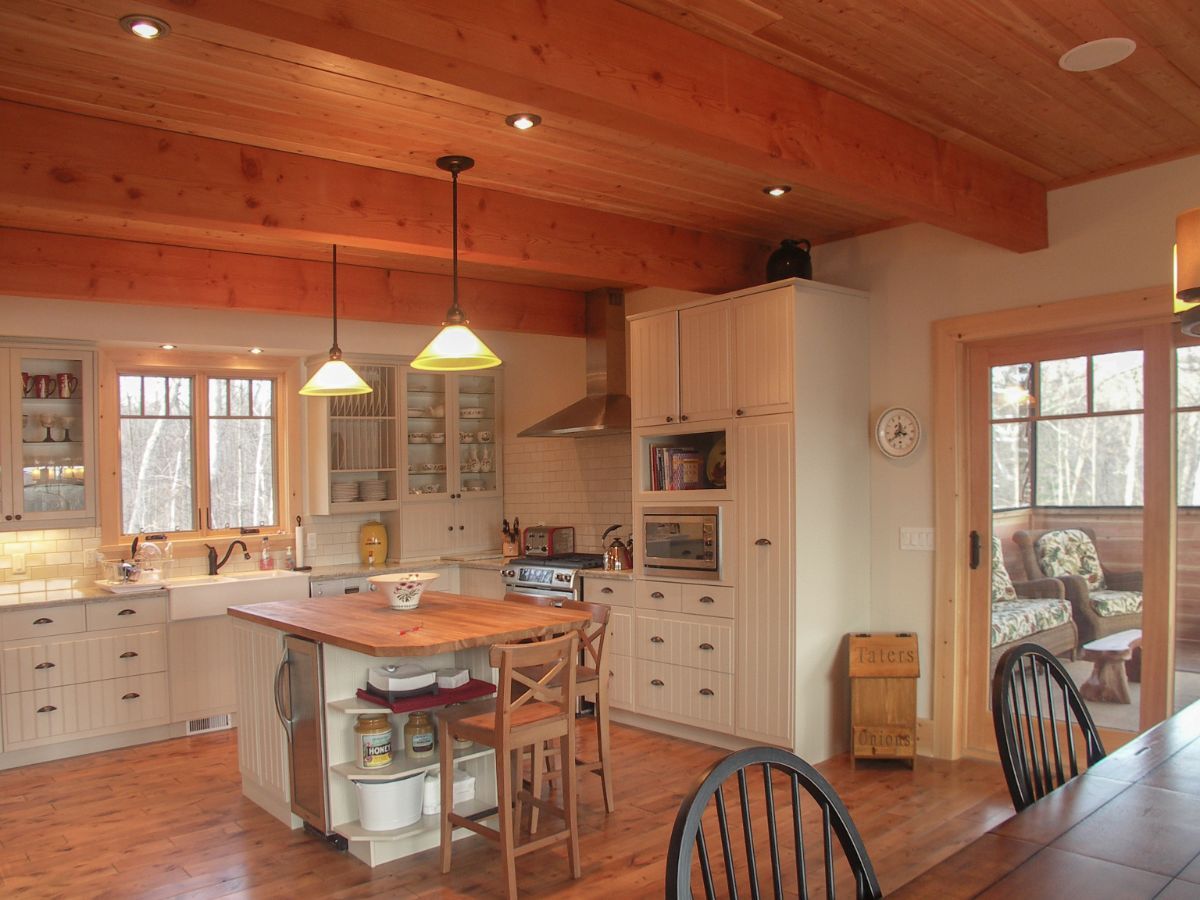 Custom Muskoka Cottage featuring a kitchen with a table and chairs and a clock on the wall
